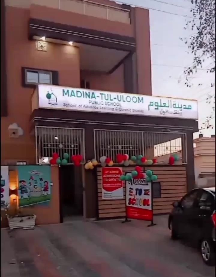 Front of the new Madina Tul Uloom campus building with the school signboard