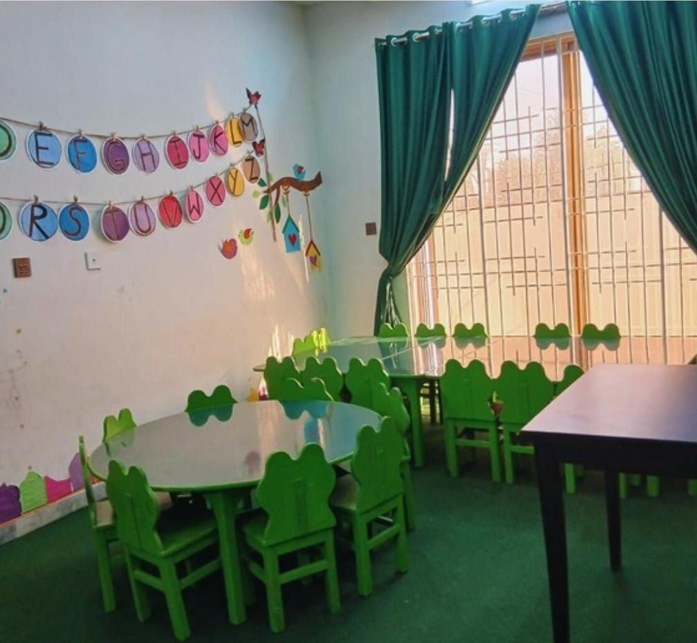 Early years classroom with green furniture and alphabet display