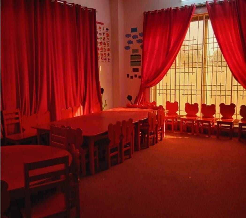 Early years classroom with red furniture and child-sized chairs
